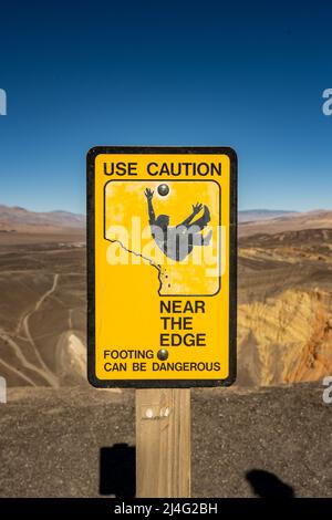Use Caution Near The Edge Sign at Ubehehe Crater Stock Photo