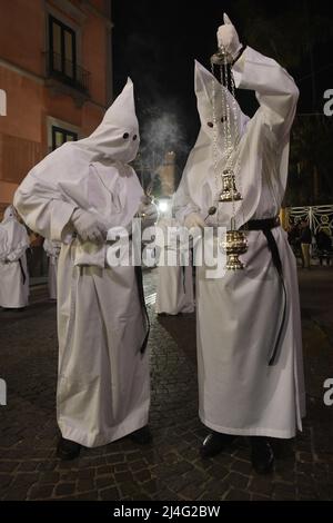 Sorrento, Italy. 14th Apr, 2022. Hooded Penitents of the Arciconfraternita di Santa Monica carry crosses and torches as they take part in Good Friday procession long the streets of Sorrento Southern Italy. Christian believers around the world mark the Holy Week of Easter in celebration of the crucifixion and resurrection of Jesus Christ. Sorrento on April 15, 2022 in Naples, Italy. Credit: Franco Romano/Alamy Live News Stock Photo