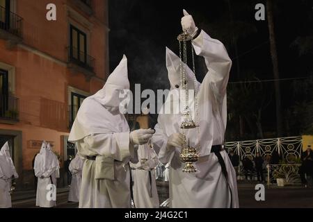 Sorrento, Italy. 14th Apr, 2022. Hooded Penitents of the Arciconfraternita di Santa Monica carry crosses and torches as they take part in Good Friday procession long the streets of Sorrento Southern Italy. Christian believers around the world mark the Holy Week of Easter in celebration of the crucifixion and resurrection of Jesus Christ. Sorrento on April 15, 2022 in Naples, Italy. Credit: Franco Romano/Alamy Live News Stock Photo