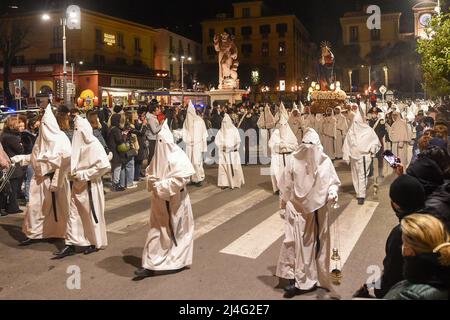 Sorrento, Italy. 14th Apr, 2022. Hooded Penitents of the Arciconfraternita di Santa Monica carry crosses and torches as they take part in Good Friday procession long the streets of Sorrento Southern Italy. Christian believers around the world mark the Holy Week of Easter in celebration of the crucifixion and resurrection of Jesus Christ. Sorrento on April 15, 2022 in Naples, Italy. Credit: Franco Romano/Alamy Live News Stock Photo