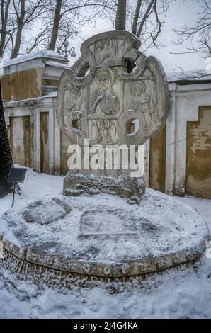 The grave of the composer Rimsky Korsakov with its art nouveau headstone by Nicholas Roerich. In the Tikhvin Cemetery at the Alexander Nevsky Monastery in St Petersburg.  Photographed in snow during winter. Stock Photo