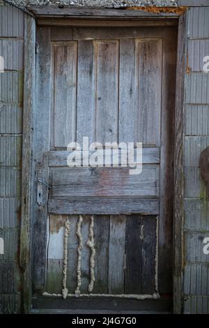 Old wooden rustic doors on rural home wall. Stock Photo
