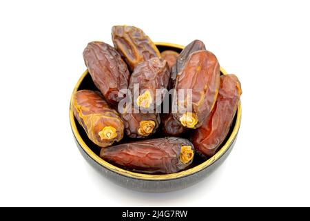 Date fruit isolated on a white background. A bowl of date fruit (Medjoul). close up Stock Photo