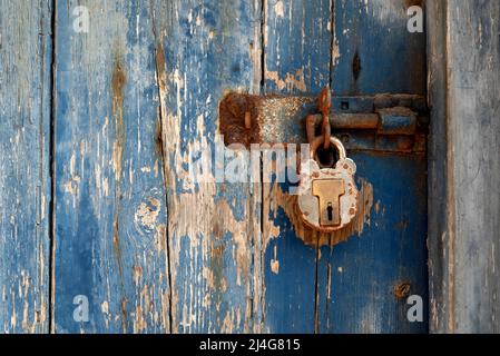Old blue wooden door with rusty lock Stock Photo
