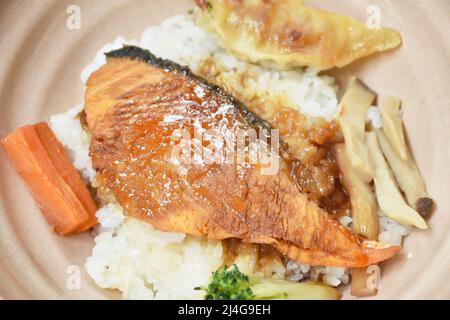 grilled salmon soy sauce with pork dumpling and vegetable topping on Japanese rice in bowl Stock Photo