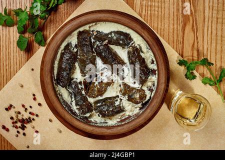 Georgian dolma from vine leaves with rice and minced meat in matsoni Stock Photo