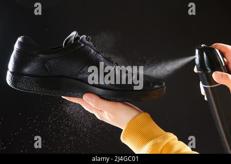 The process of applying a water-repellent spray to black men's leather demi-season shoes Stock Photo