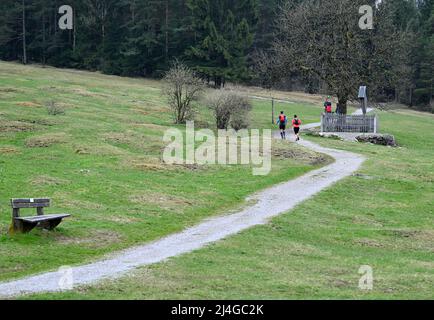 Farchant, Germany. 15th Apr, 2022. Joggers run along a hiking trail during a break in the rain. Very changeable is the weather on Good Friday in Bavaria. Credit: Angelika Warmuth/dpa/Alamy Live News Stock Photo