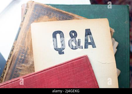 Q and A written on a vintage yellowed page, coming out of an old dusty book Stock Photo