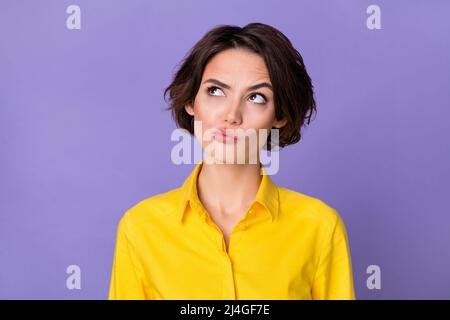 Photo of hr young bob hairdo lady look up wear yellow blouse isolated on violet color background Stock Photo