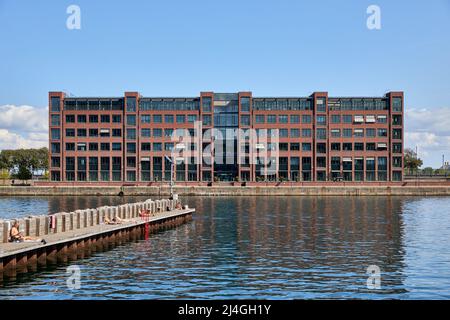 Langelinie Allé 35, building by Pakhuskaj, people on pier in foreground; Søndre Frihavn, Copenhagen, Denmark Stock Photo