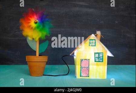 cute model home with wind turbine, clean energy,low carbon power concept Stock Photo