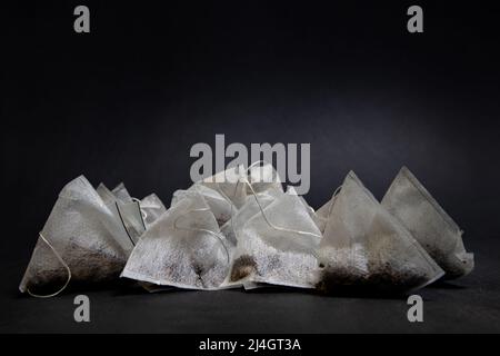 Triangular tea bags on a black background Stock Photo