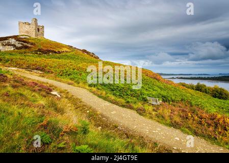 A path leads through bracken, turning autumnal, to Castle Varrich, a small ruined building on a hilltop near Tongue on the North Coast 500. Stock Photo