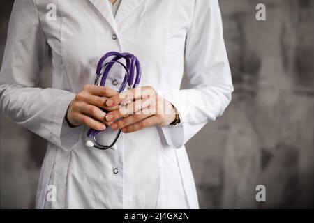 Close up image of a doctor with a stethoscope in her hands. against the background of a blurry hospital. Stock Photo