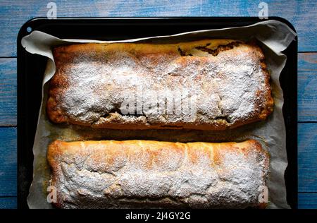 food background freshly baked strudel on a black baking tray Stock Photo