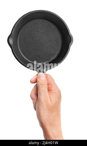 Hand holding black cast-iron frying pan, isolated on white background Stock Photo