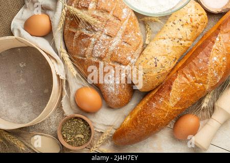 Different sorts of bread with wheat and eggs, top view. The concept of a bakery and food store. Stock Photo