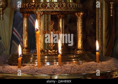 Burning candles are on a candlestick in the church. Closeup. Stock Photo