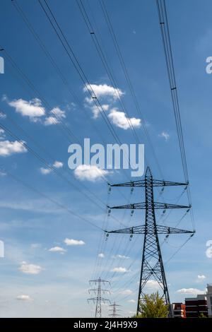 Metal pylon carrying overhead electric cables of high voltage lines. Concepts of electric transmission grids, energy supply, power consumption issues Stock Photo