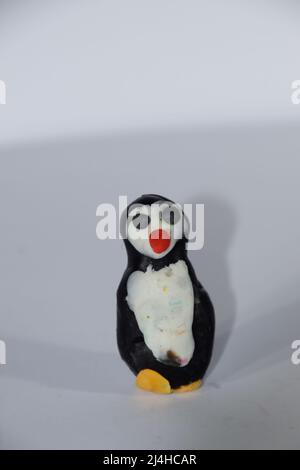 Plasticine penguin. Toys made of plasticine on a white background. Stock Photo