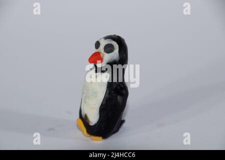 Plasticine penguin. Toys made of plasticine on a white background. Stock Photo