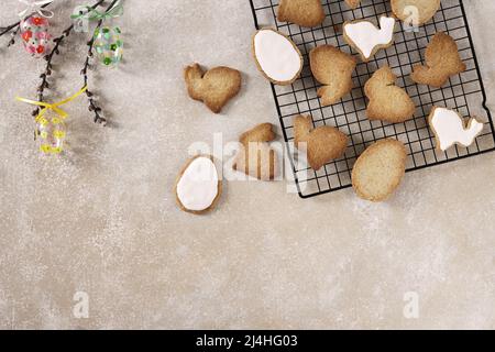 Easter glass eggs, willow twigs and Cookies in shape of easter bunny and easter eggs. Biege background top view space for text Stock Photo