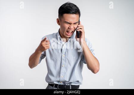 man shocked and angry while talking on his smartphone Stock Photo