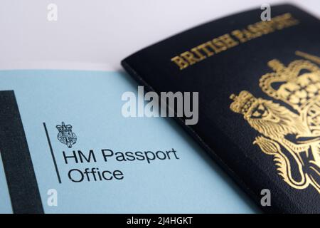 HM Passport Office logo seen on the genuine letter and blurred UK passport on the background. Concept. Stafford, United Kingdom, April 15, 2022. Stock Photo