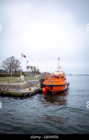 in the port of Rostock lies a orange distress rescue ship Stock Photo