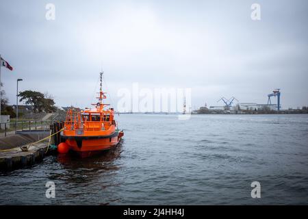 in the port of Rostock lies a orange distress rescue ship Stock Photo