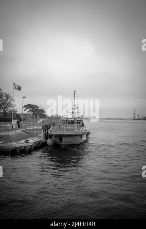 in the port of Rostock lies a orange distress rescue ship Stock Photo