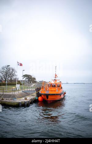 in the port of Rostock lies a orange distress rescue ship Stock Photo