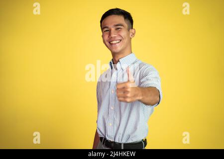asian young man showing thumbs up with smiling teeth Stock Photo
