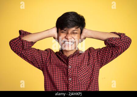 Stressed asian young young man holding head Stock Photo