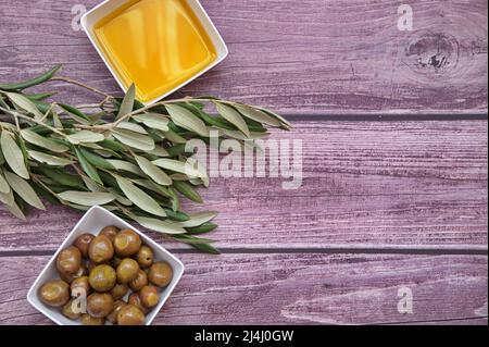 Olives, olive oil and olive branch on wooden background Stock Photo
