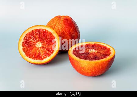 Half of blood red orange citrus fruit on blue background. red orange half with clipping path Stock Photo