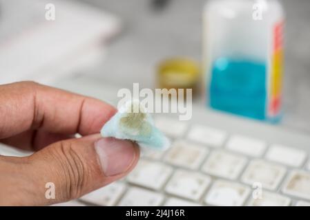 The man cleaning his computer keyboard. Grimy, more bacteria on keyboard. Stock Photo