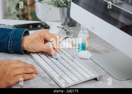 The man cleaning his computer keyboard. Grimy, more bacteria on keyboard. Stock Photo