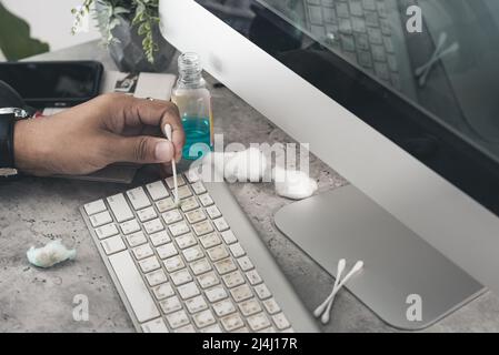 The man cleaning his computer keyboard. Grimy, more bacteria on keyboard. Stock Photo