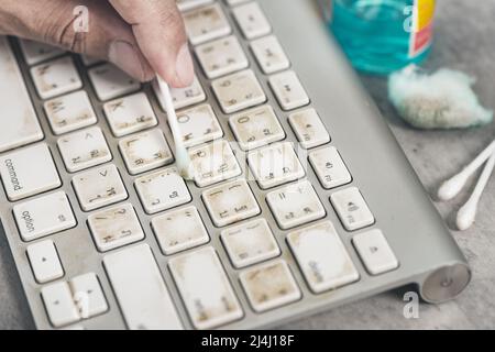 The man cleaning his computer keyboard. Grimy, more bacteria on keyboard. Stock Photo