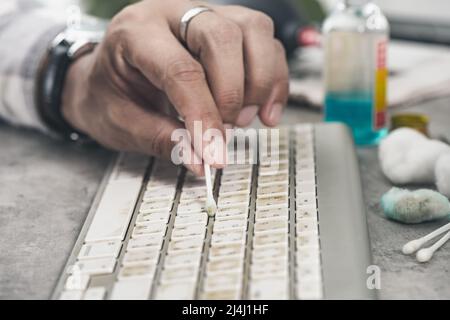 The man cleaning his computer keyboard. Grimy, more bacteria on keyboard. Stock Photo