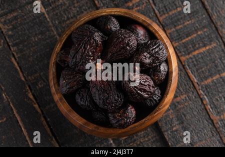Bowl of Dark Dried Mission Figs on a Dark Wood Table Stock Photo