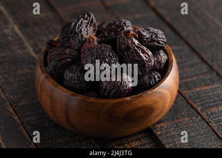 Bowl of Dark Dried Mission Figs on a Dark Wood Table Stock Photo