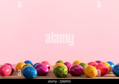 Scattered colored chicken eggs on linen fabric. Easter. Stock Photo