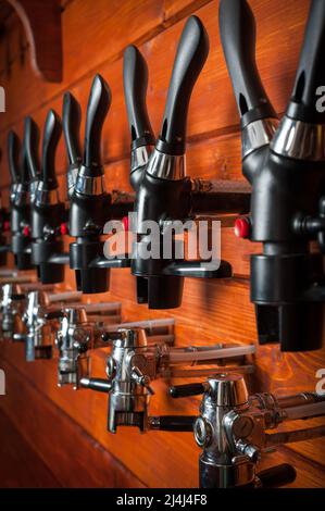 Beer taps for draught drinks are built into wooden boards Stock Photo