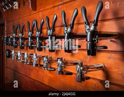 Beer taps for draught drinks are built into wooden boards Stock Photo