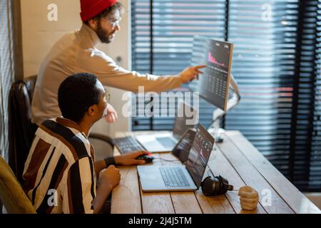 Two men working on computer at home office Stock Photo