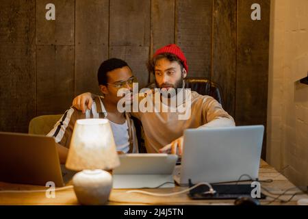 Gay couple working on computers at home office Stock Photo