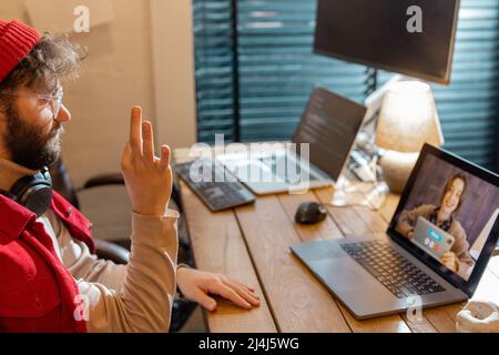 Man having online meeting with female colleague, while work at home Stock Photo